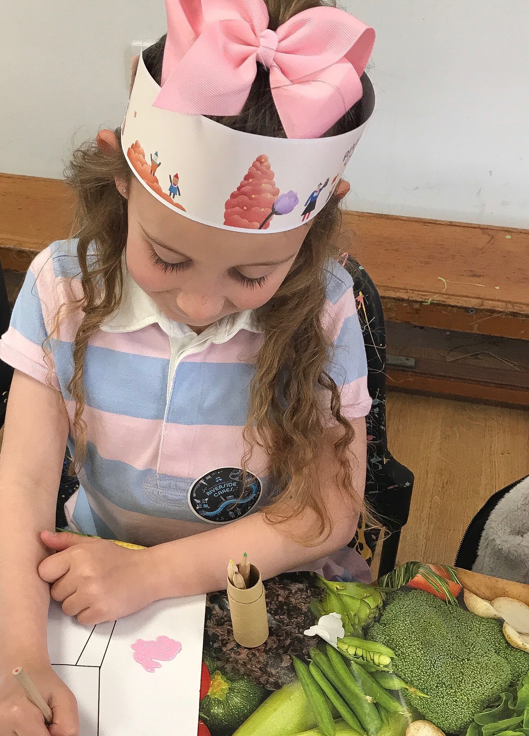 Child with headband creating art